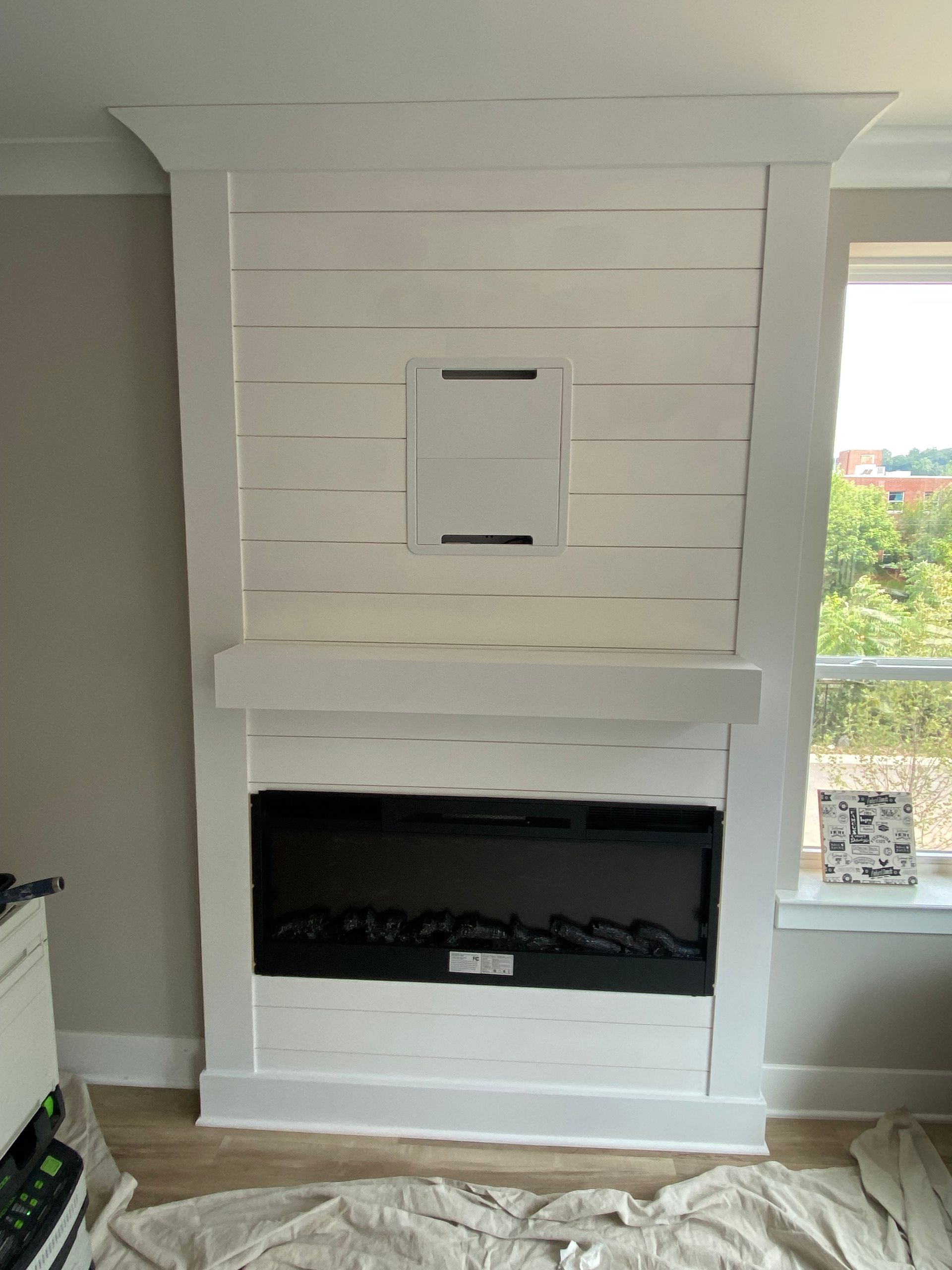 A living room with a fireplace and a window