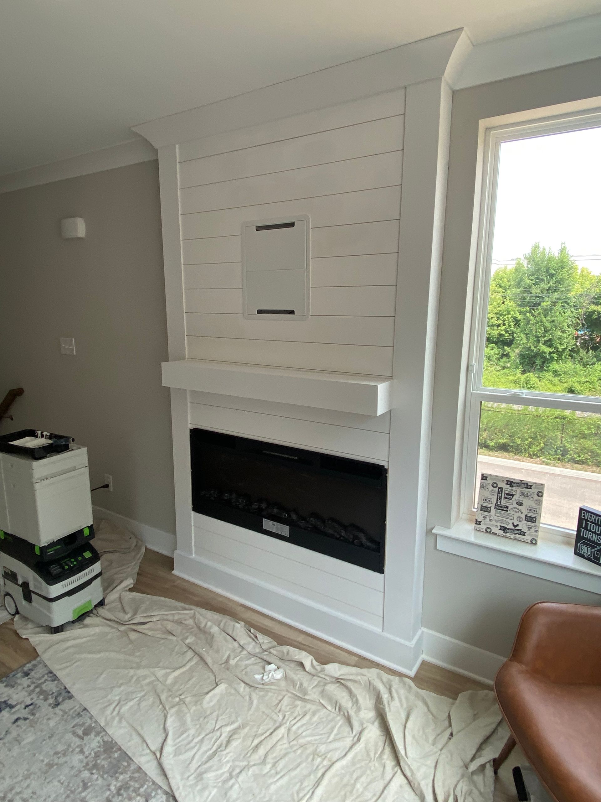 A living room with a fireplace and a window