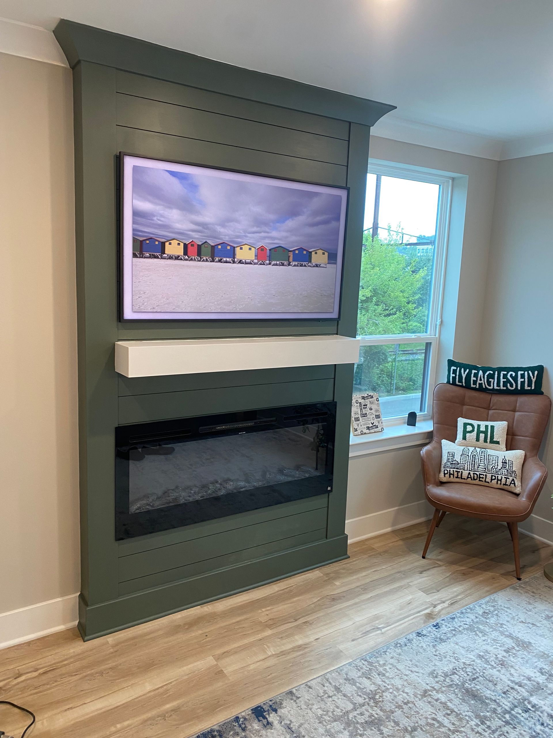 A living room with a fireplace and a tv on the wall