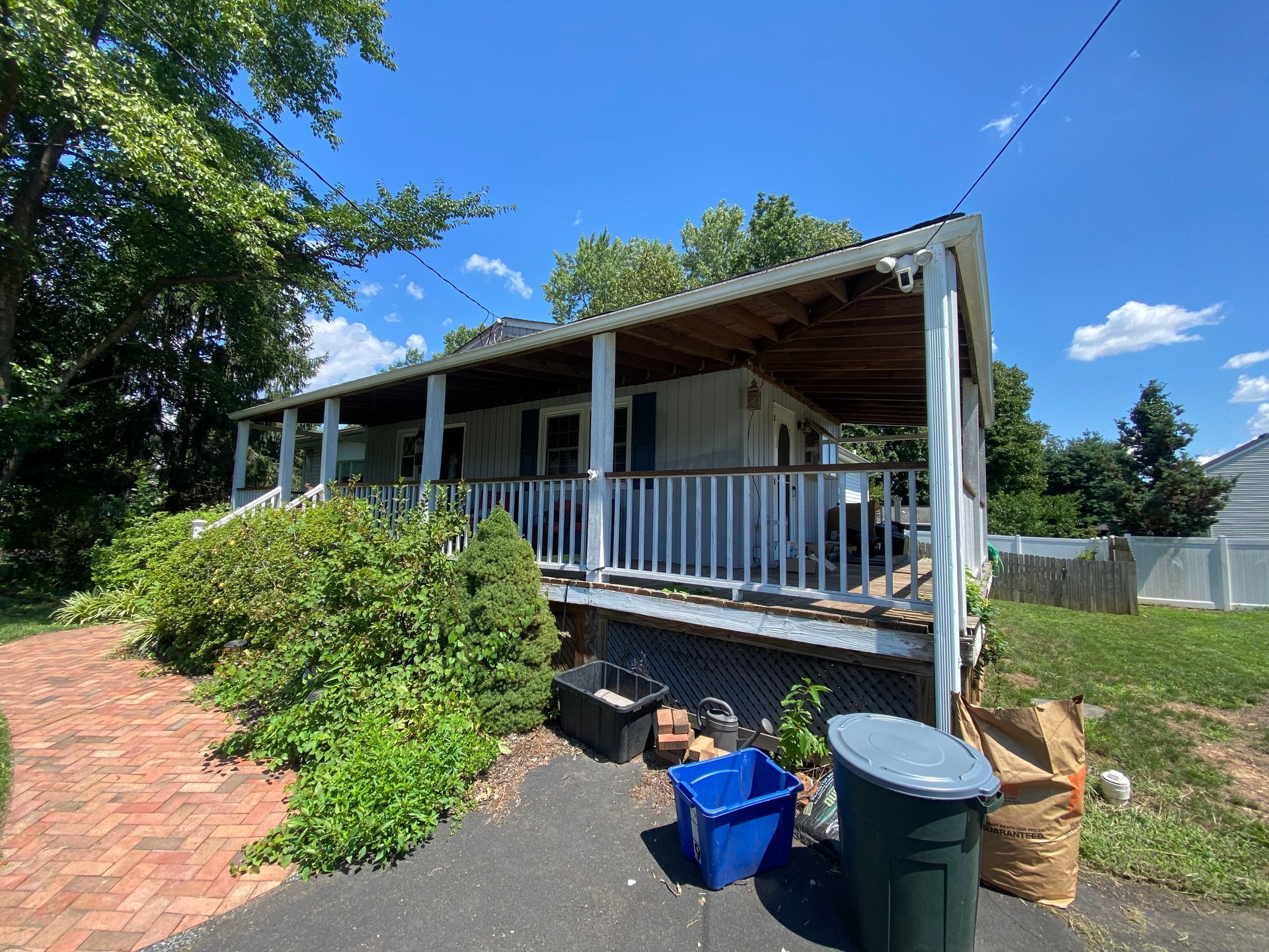 A house with a porch and a lot of trash in front of it