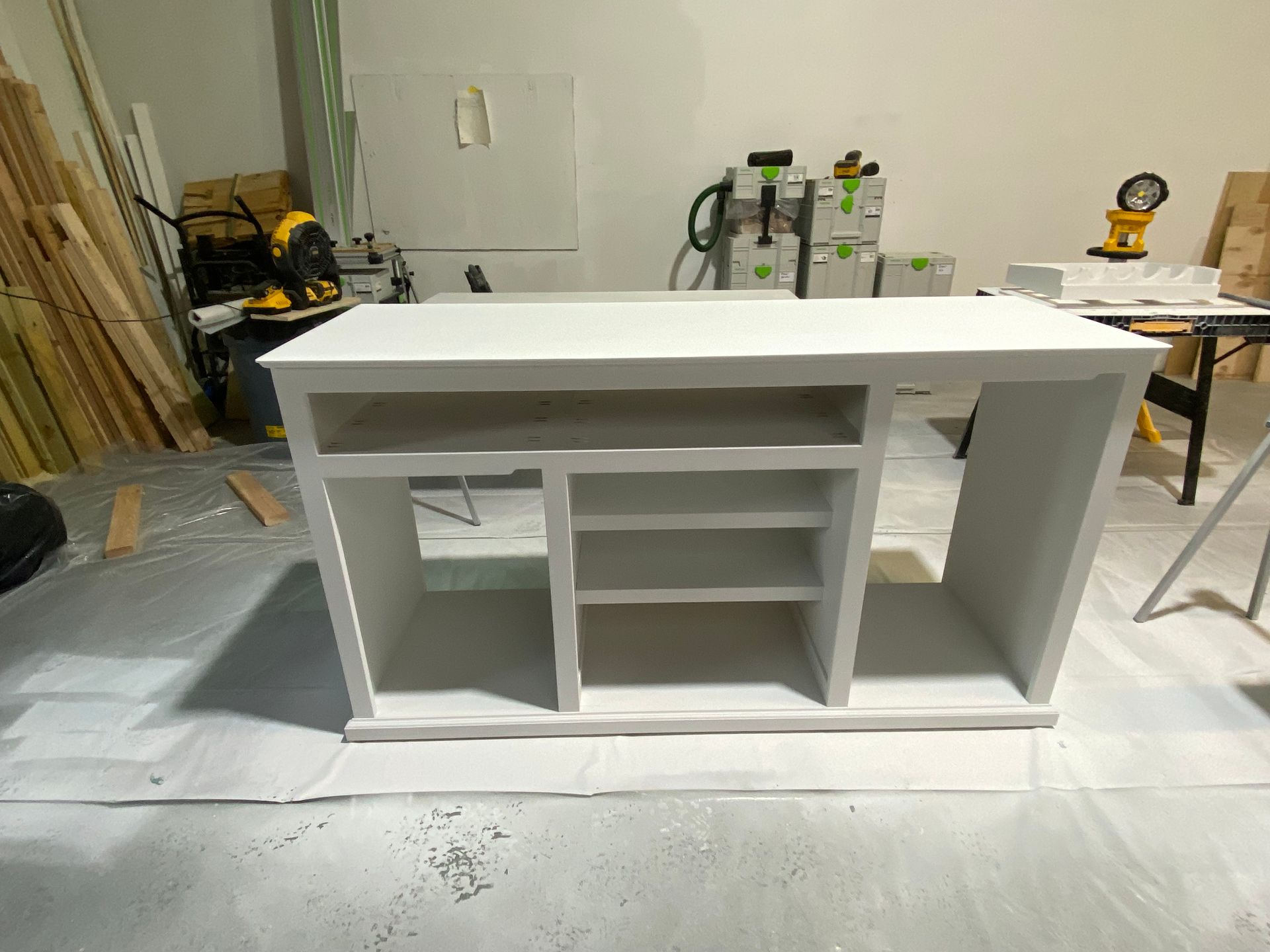 A white shelf is sitting on a table in a room.