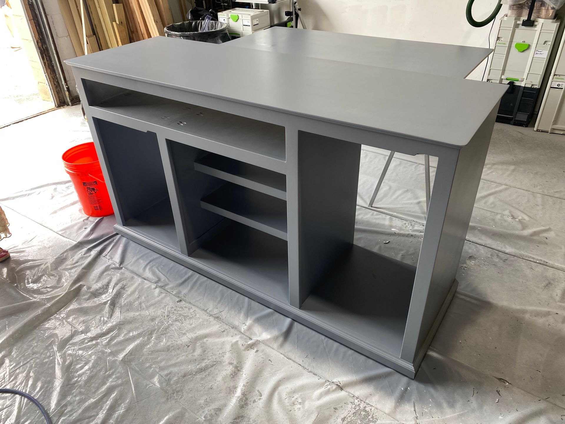 A gray cabinet is sitting on a white table in a room.