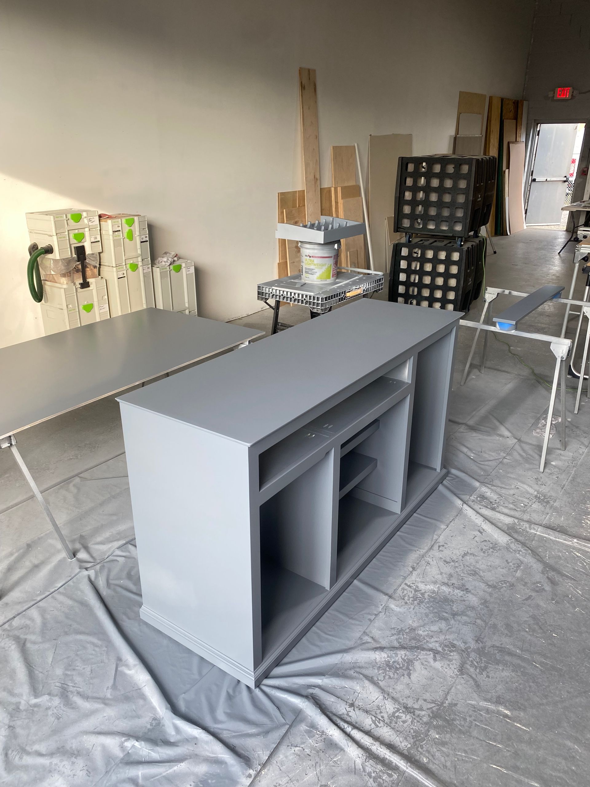 A gray cabinet is sitting on a white cloth in a room.