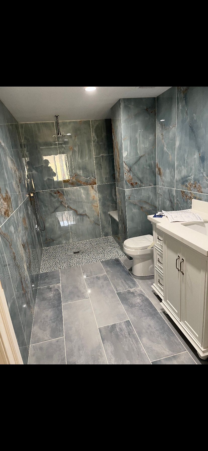 A bathroom with a toilet , sink , and walk in shower.