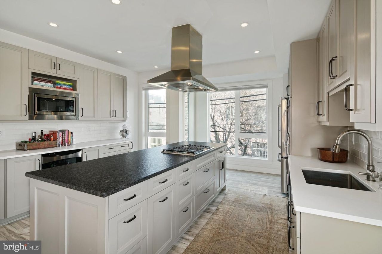 A kitchen with a large island and a stove top oven.
