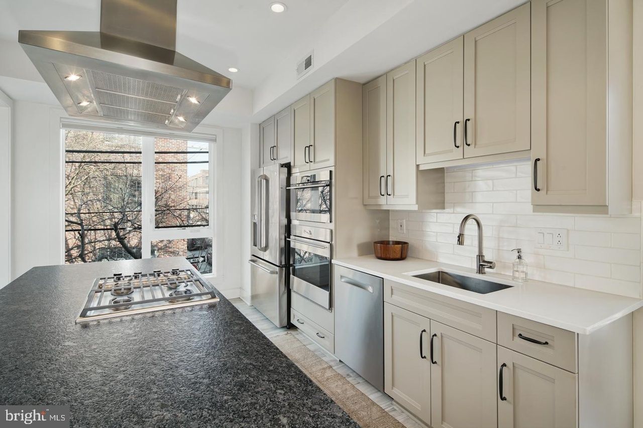 A kitchen with stainless steel appliances and white cabinets