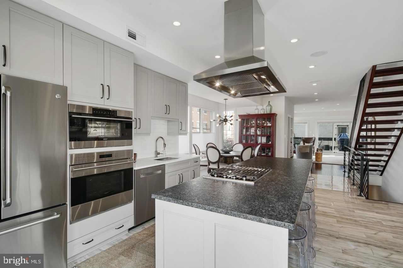 A kitchen with stainless steel appliances and a large island.
