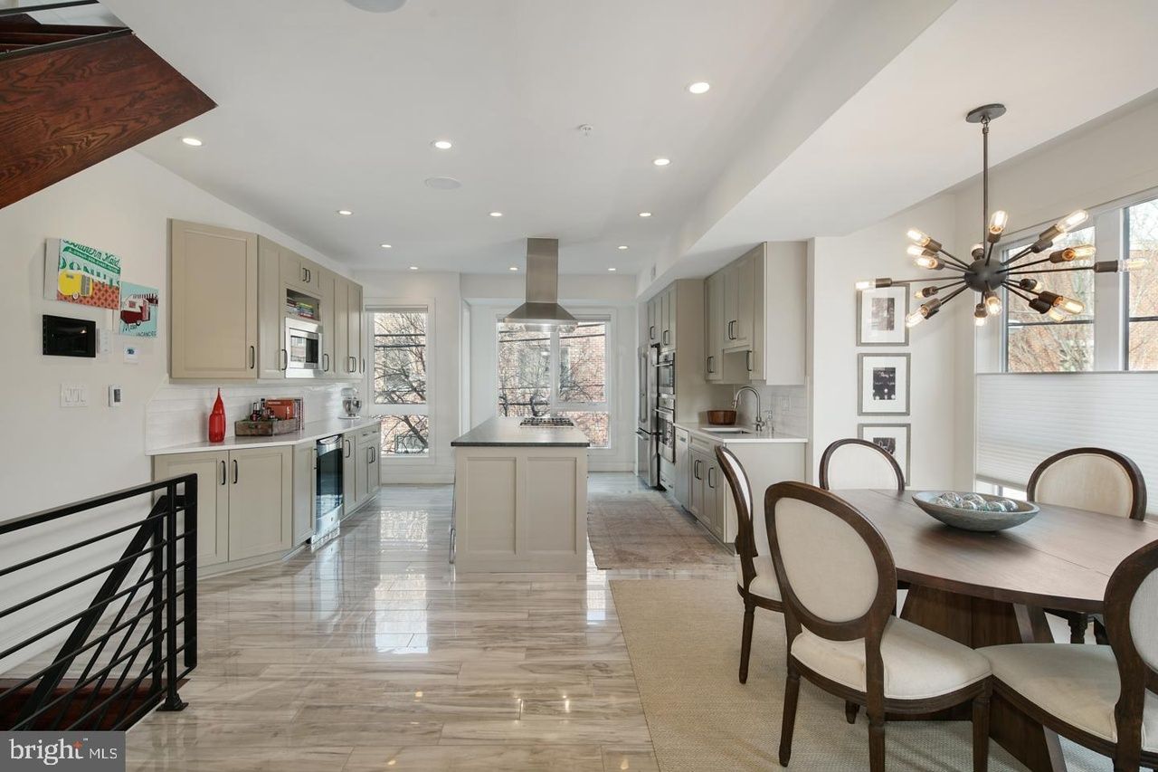 A kitchen and dining room in a house with a table and chairs.