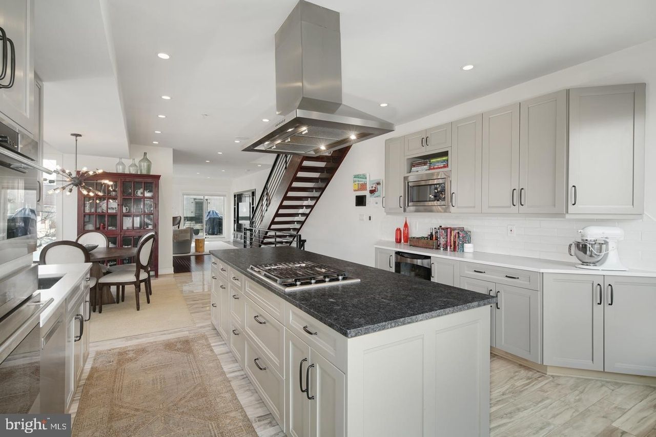 A kitchen with a large island and a stove top oven.