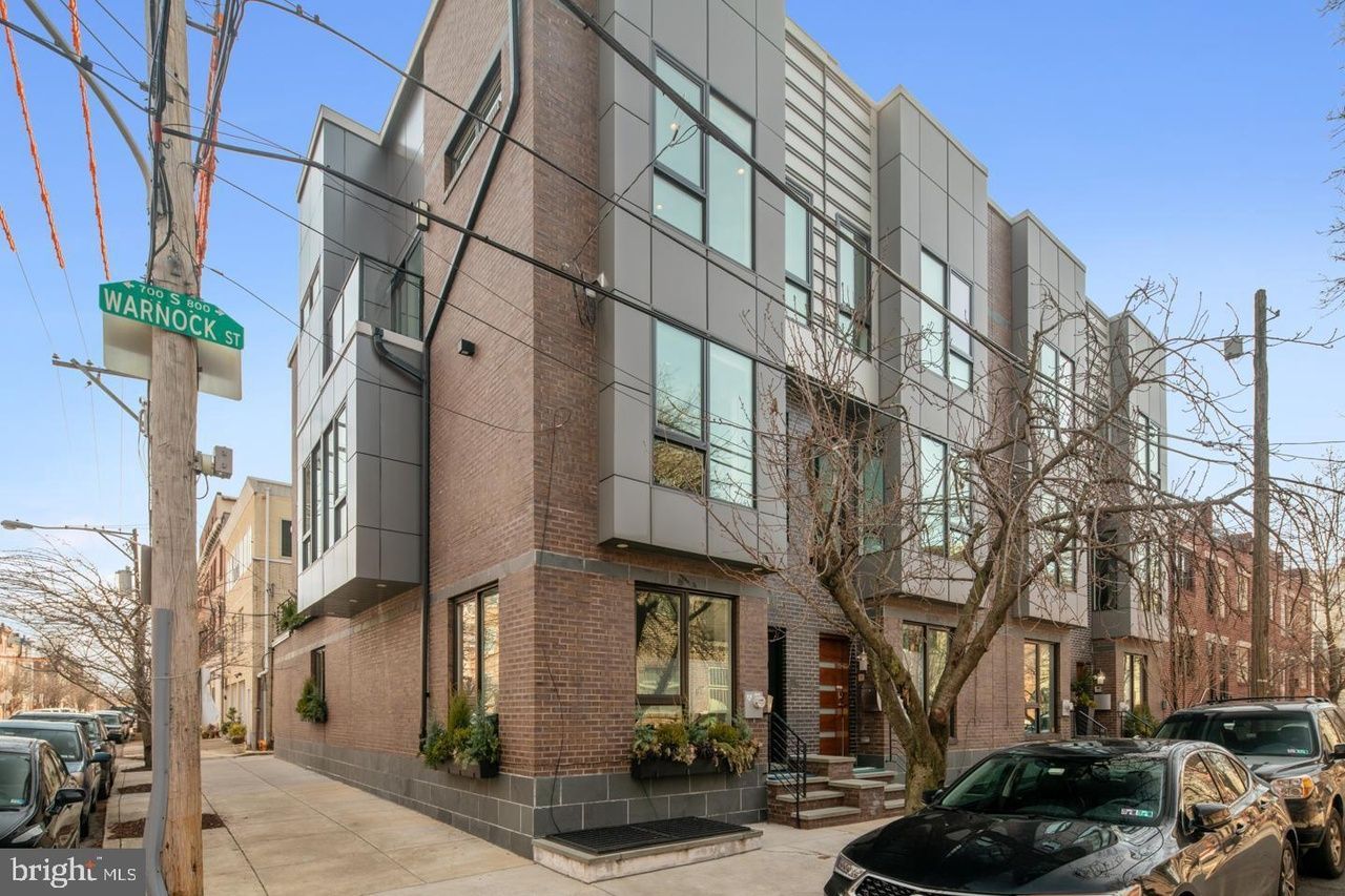 A building with a lot of windows and a car parked in front of it.