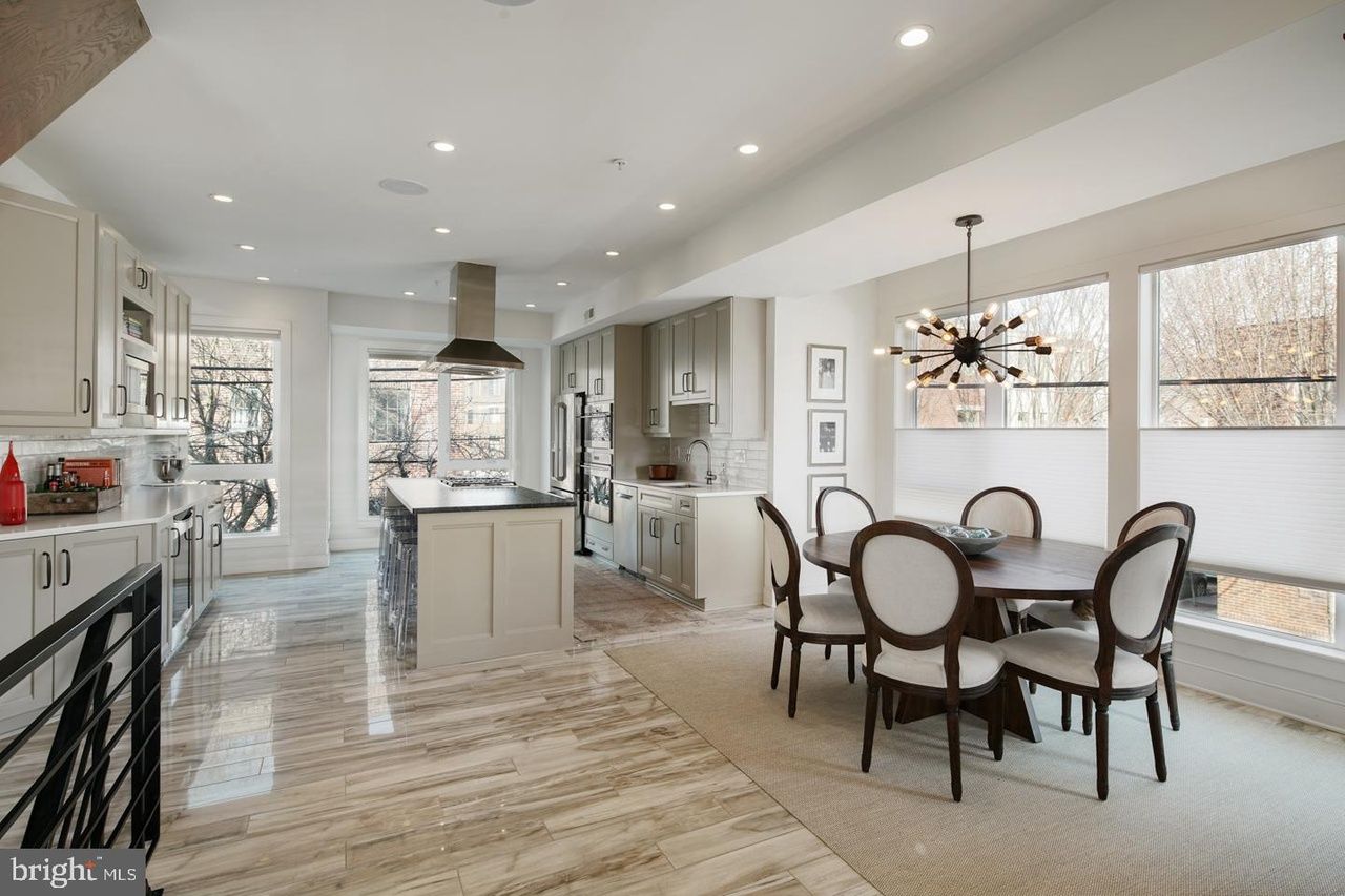 A kitchen and dining room in a house with a table and chairs.