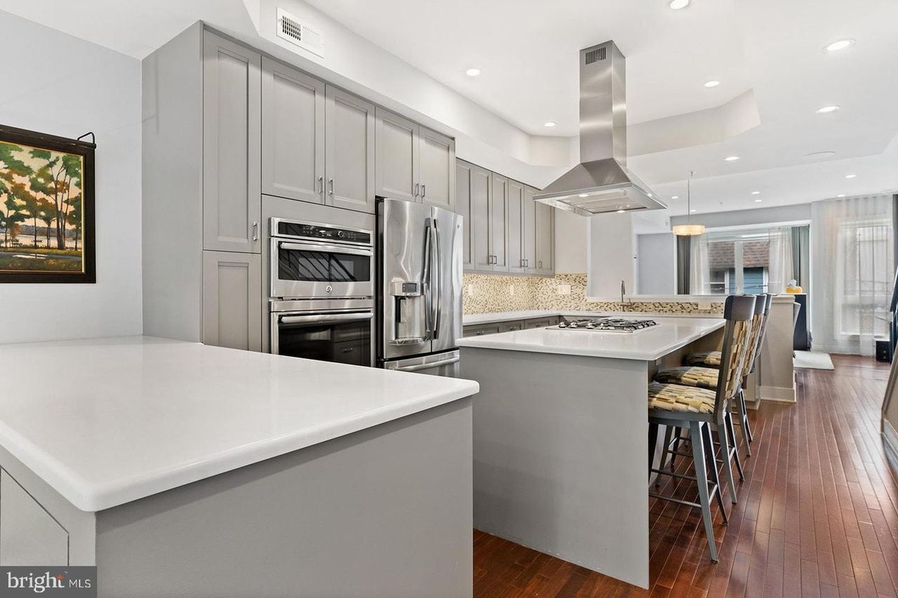A kitchen with a large island and stainless steel appliances.
