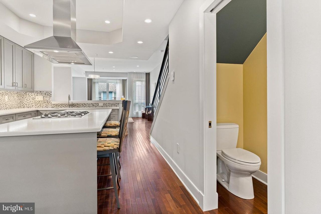 There is a toilet in the hallway between the kitchen and the bathroom.