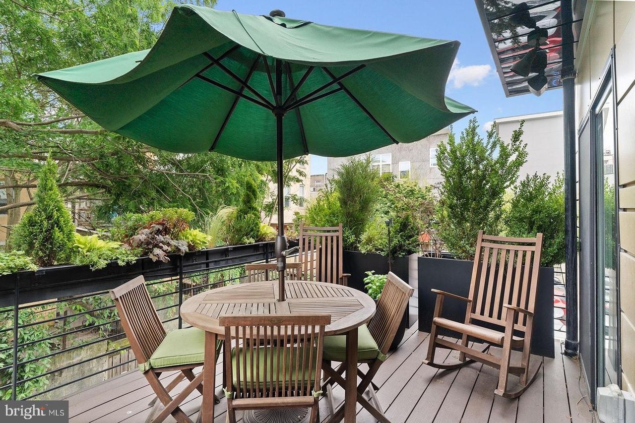 A deck with a table and chairs and an umbrella