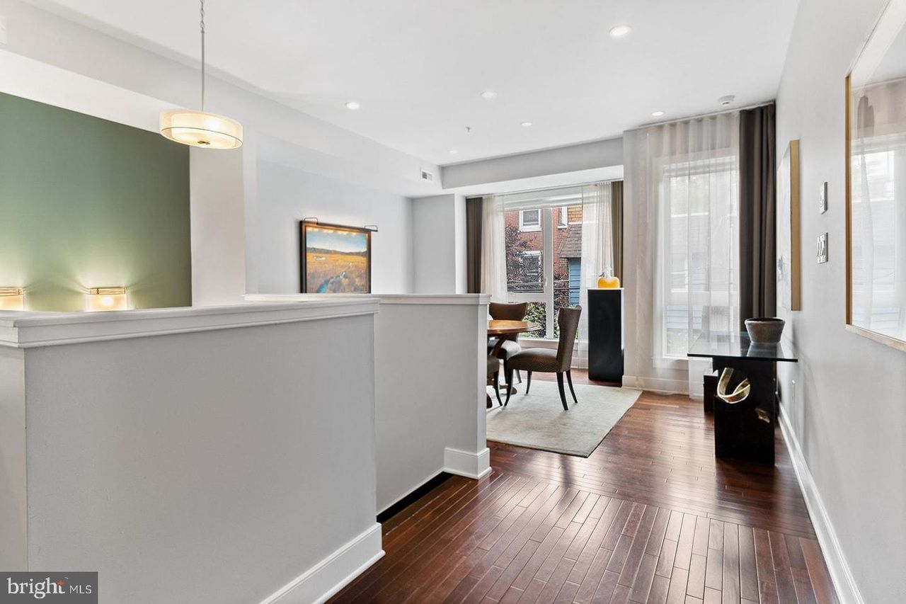 A hallway in a house with hardwood floors and white walls.