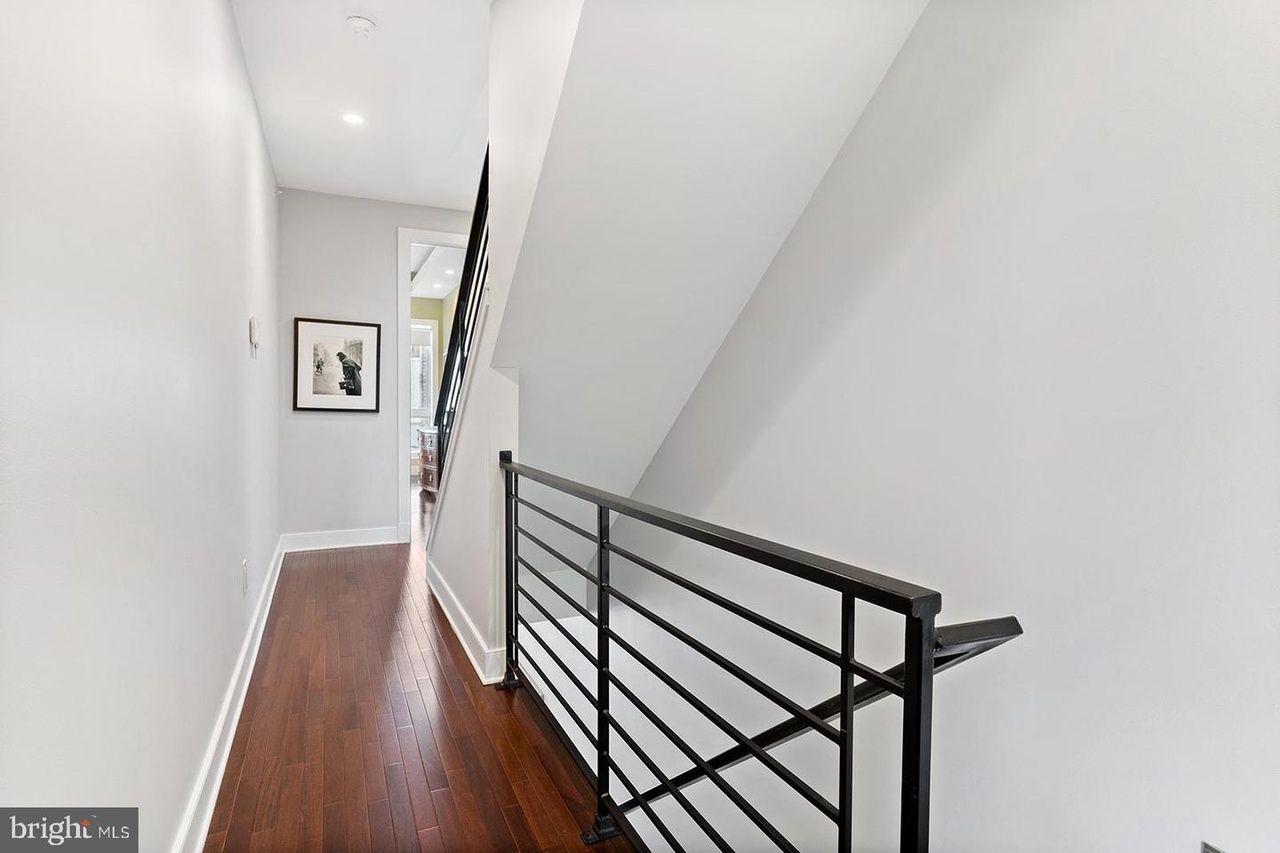 A hallway with a railing and stairs in a house