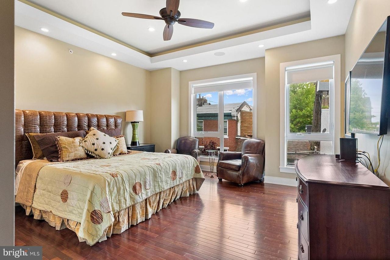 A bedroom with a king size bed , chair , dresser and television.