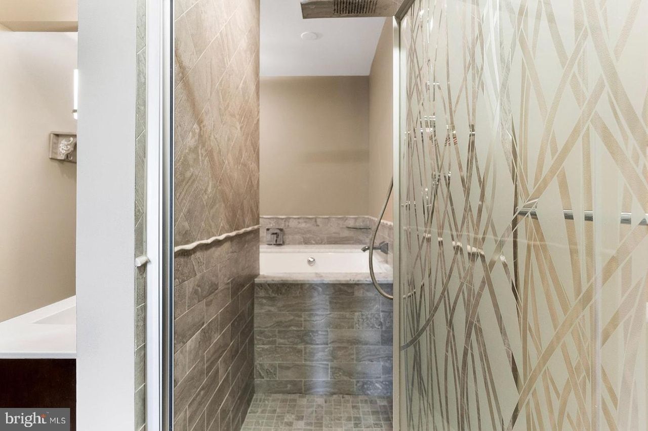 A bathroom with a tub and a walk in shower.