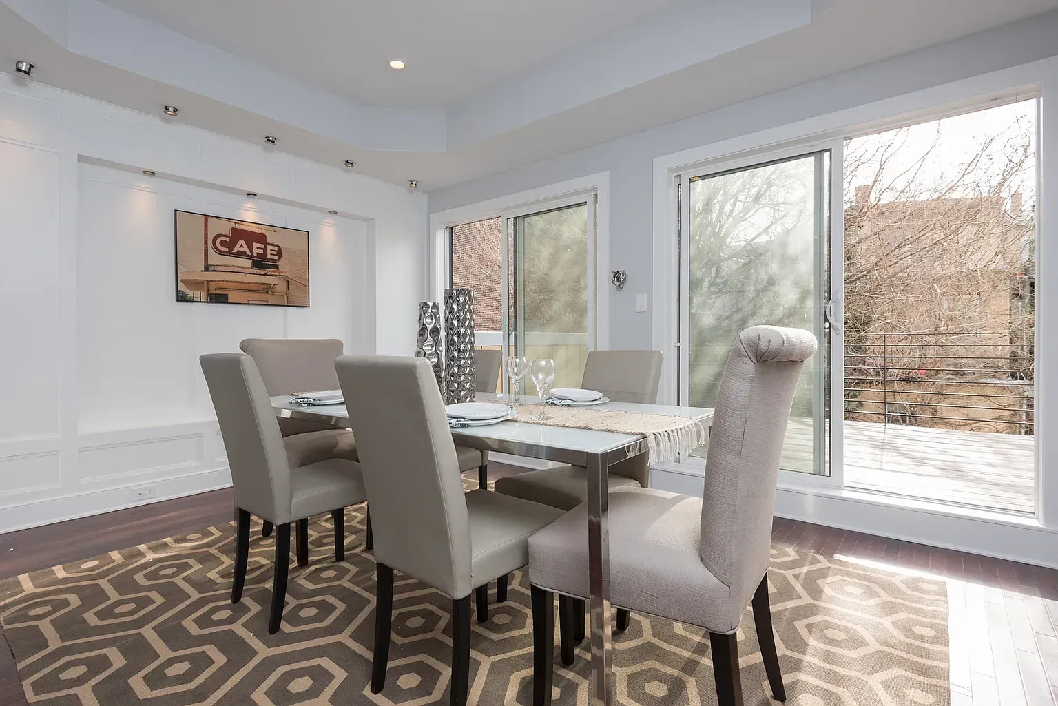A dining room with a table and chairs and a rug.