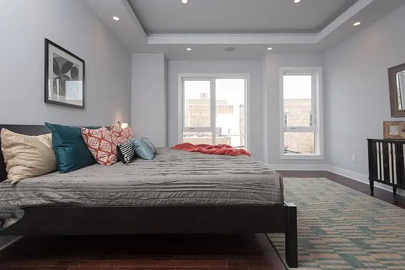 A bedroom with a large bed and lots of windows.