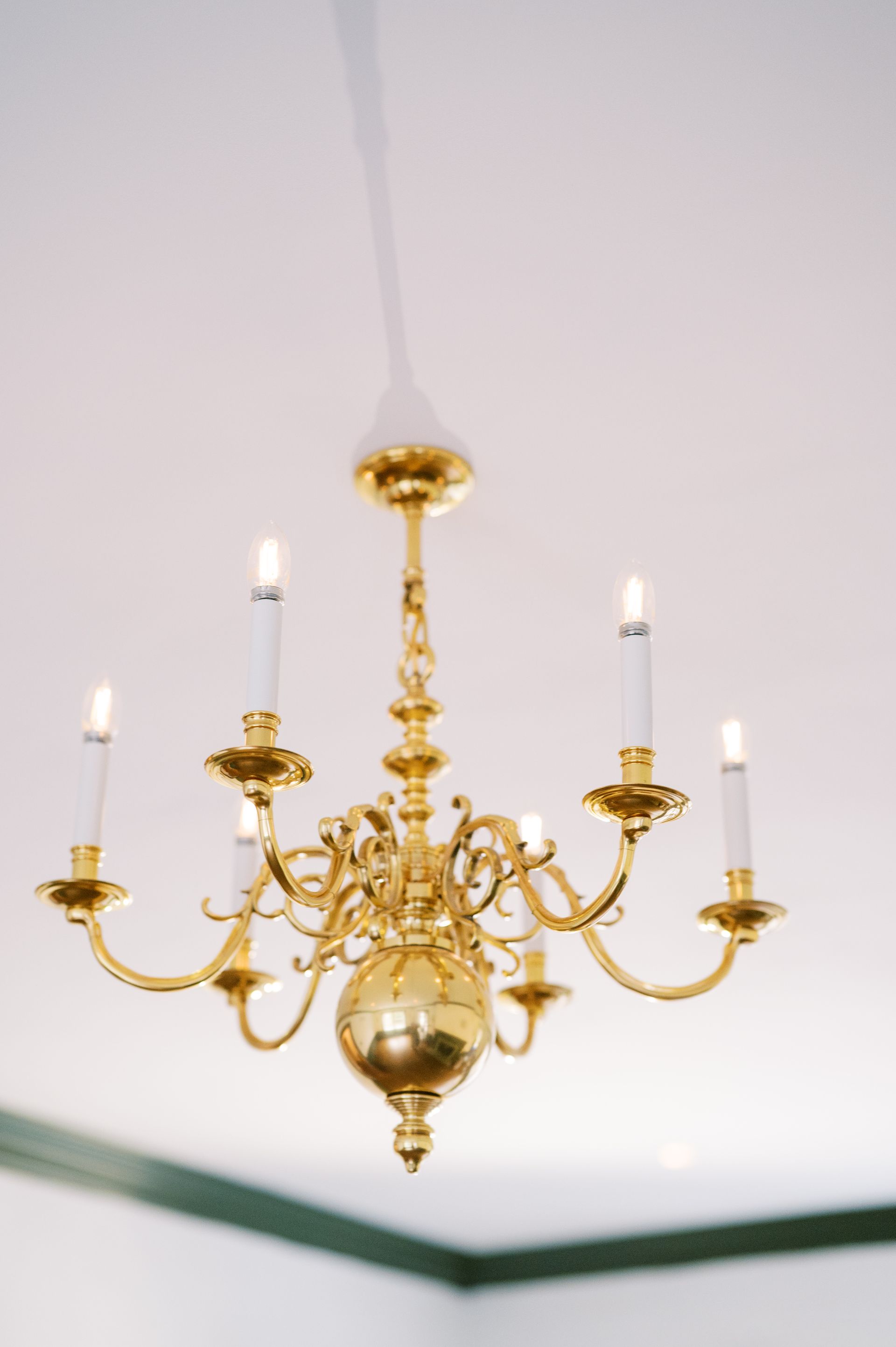 A gold chandelier with candles hanging from the ceiling