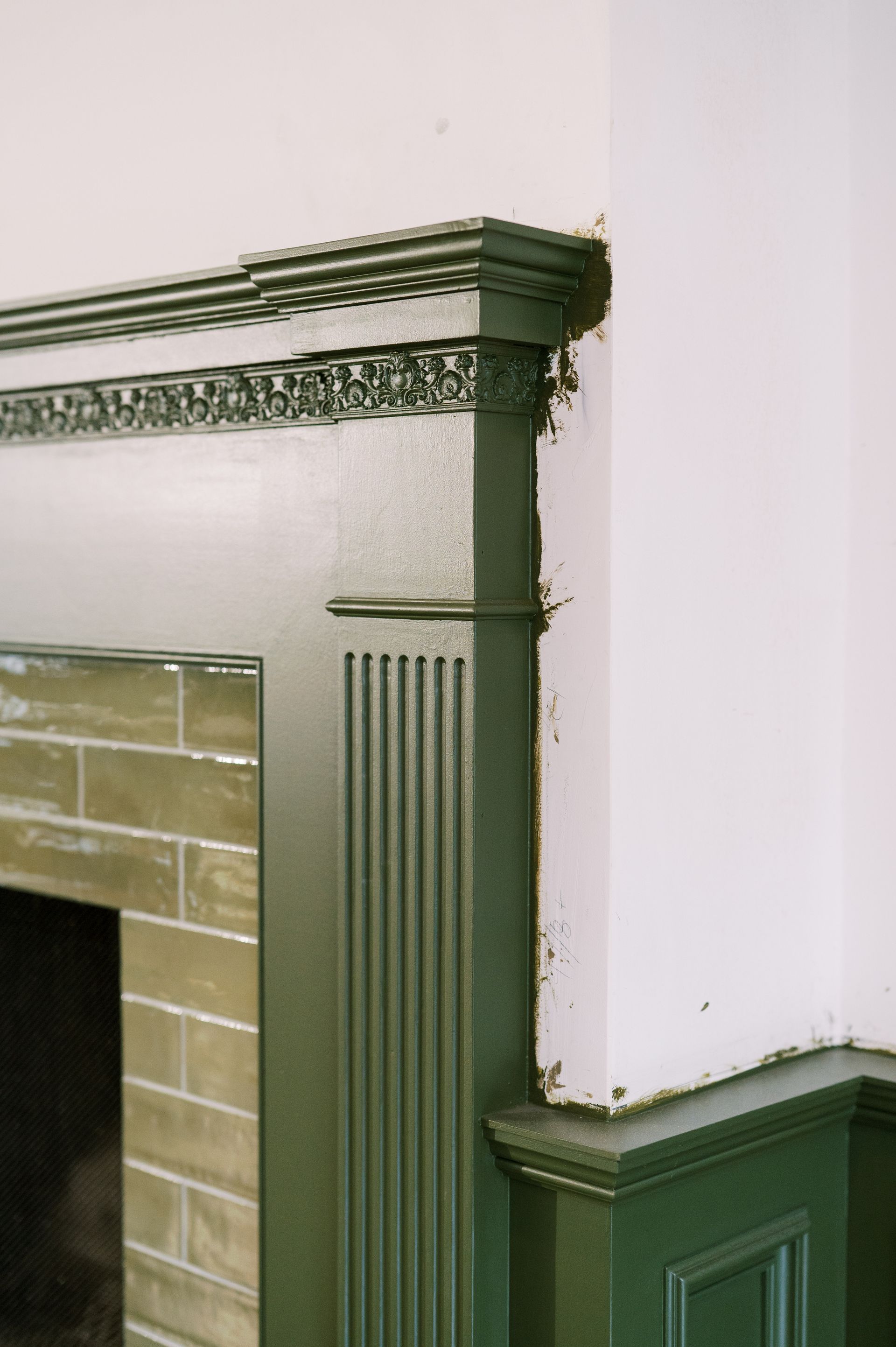 A fireplace in a room with a green trim
