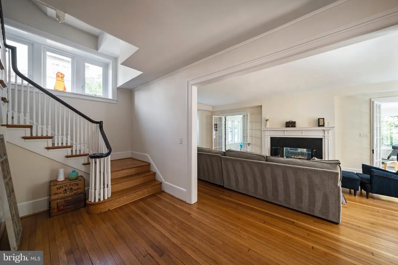 A living room with hardwood floors , stairs and a fireplace.