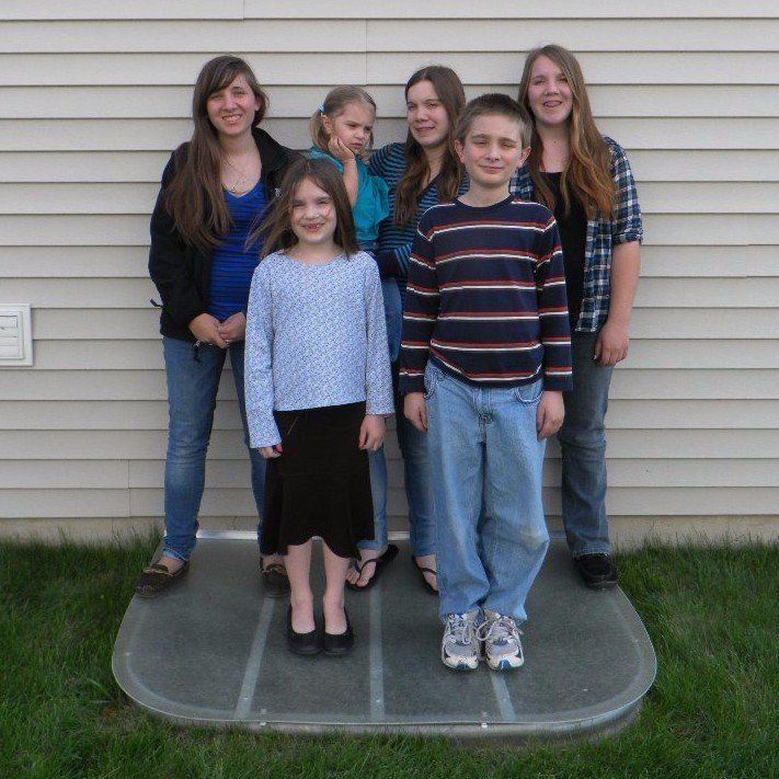 A group of people posing for a picture in front of a house