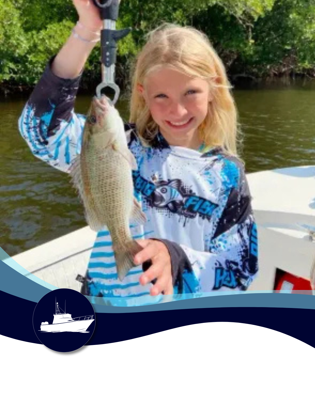 Young girl smiles while holding a fish she caught on a boat, with a forested background.
