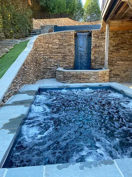 There is a waterfall in the middle of the pool.