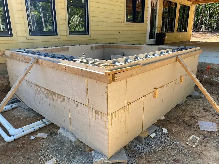 A hot tub is being built in front of a house.