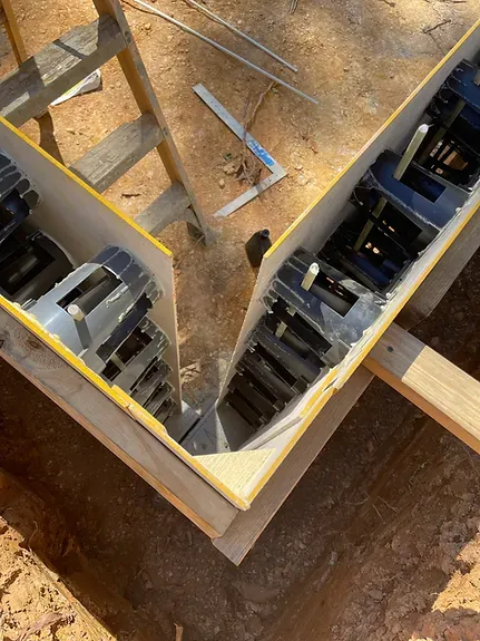 A wooden panel system is being built in the dirt