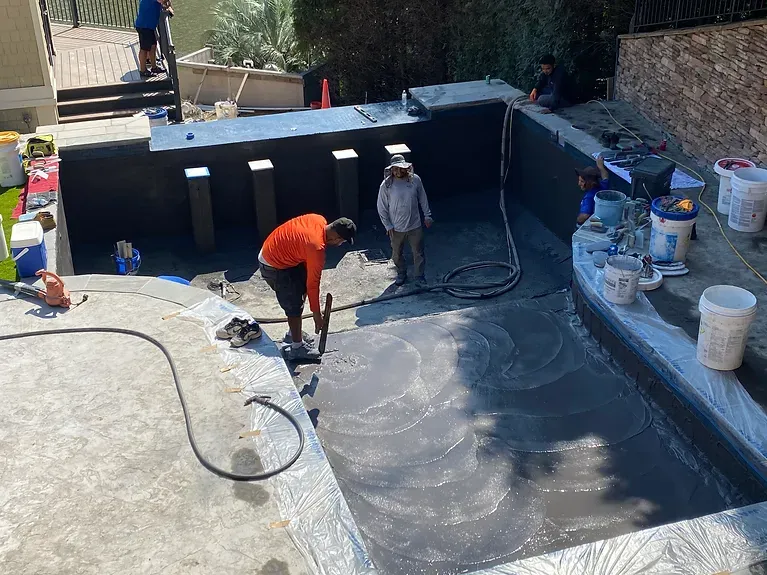 A group of people are working on a swimming pool.