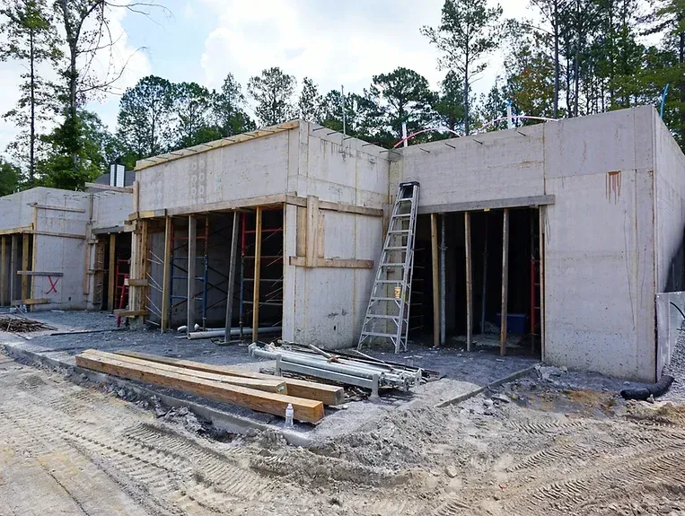 A ladder is sitting in front of a building under construction.