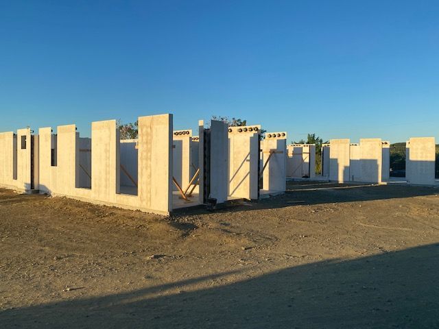 A row of concrete blocks in a field with a blue sky in the background
