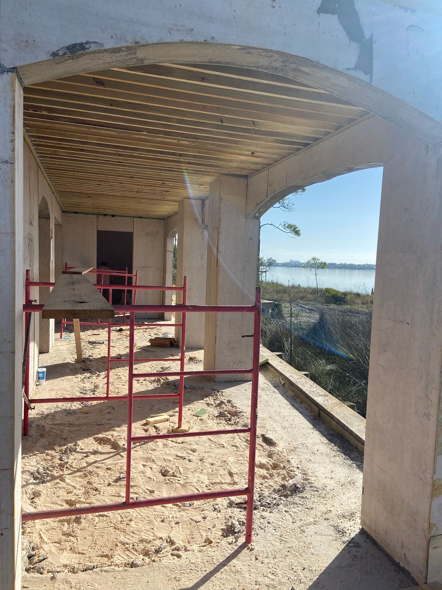 A building under construction with a red scaffolding in front of it