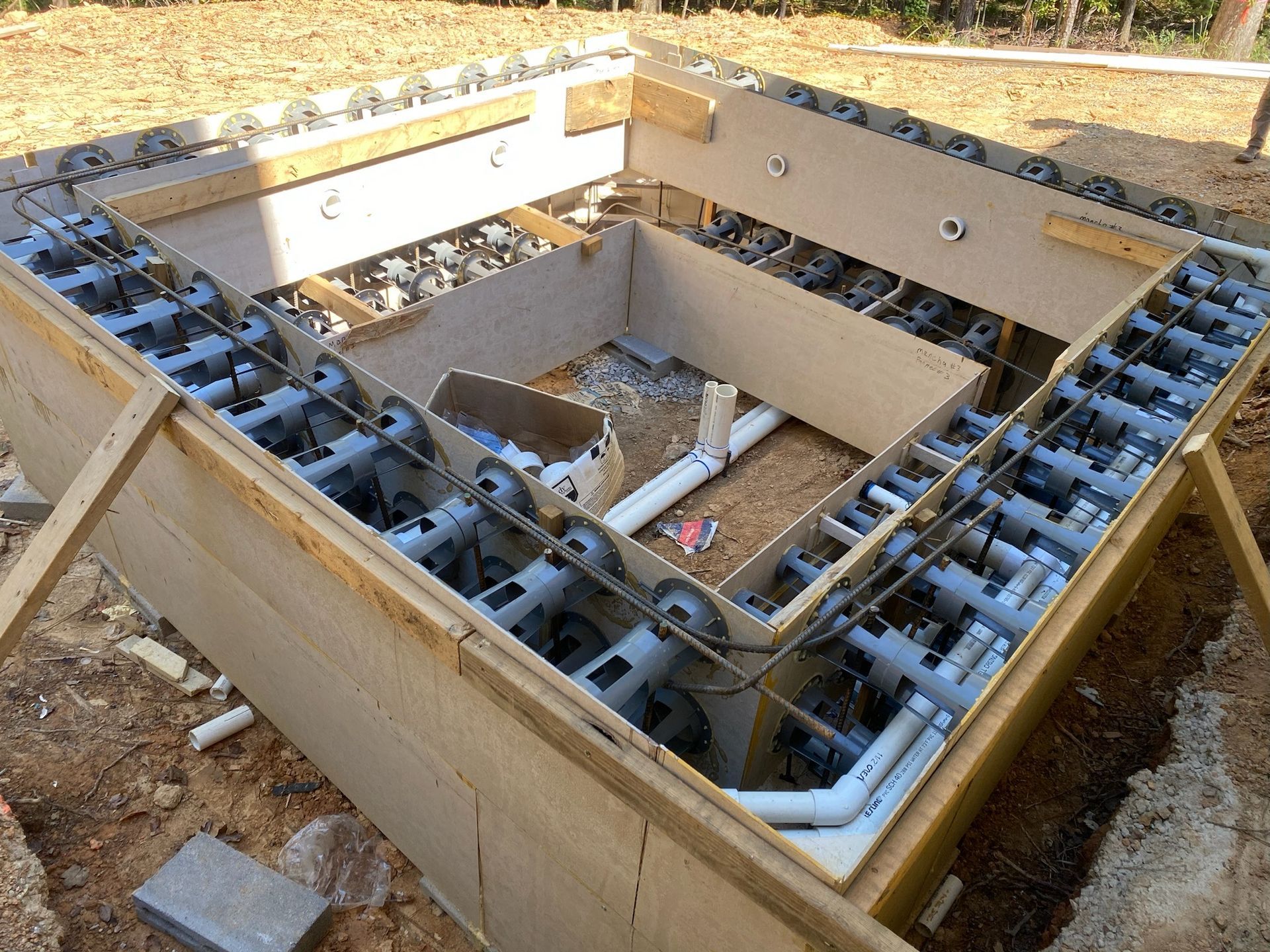 A large wooden box is sitting on top of a dirt field.