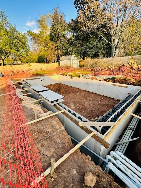 A large swimming pool is being built in a backyard.