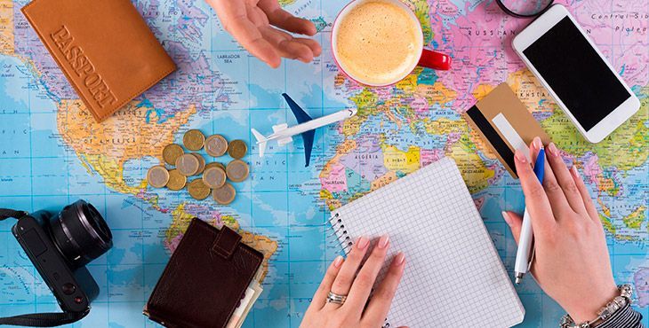  Pessoa calculando o orçamento de viagem com mapa e passaporte sobre a mesa