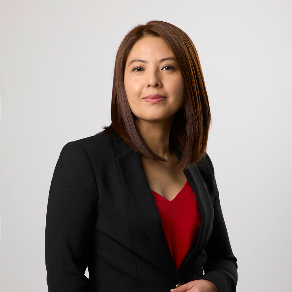 A woman wearing a black jacket and a red top