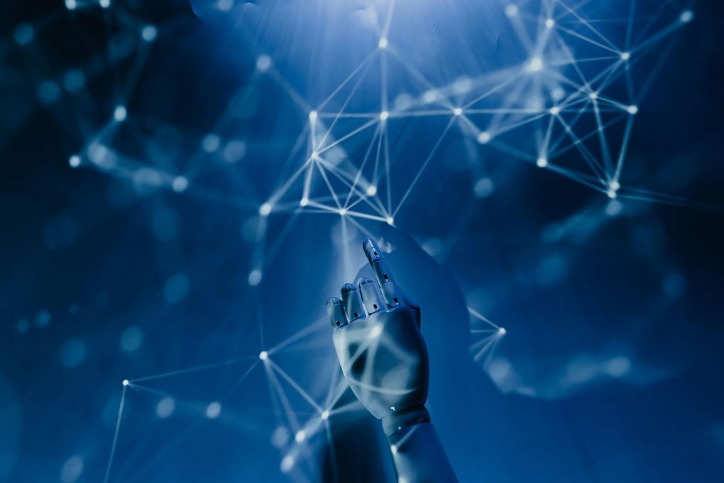 Robotic hand touching a network of connected nodes, all against a blue background.