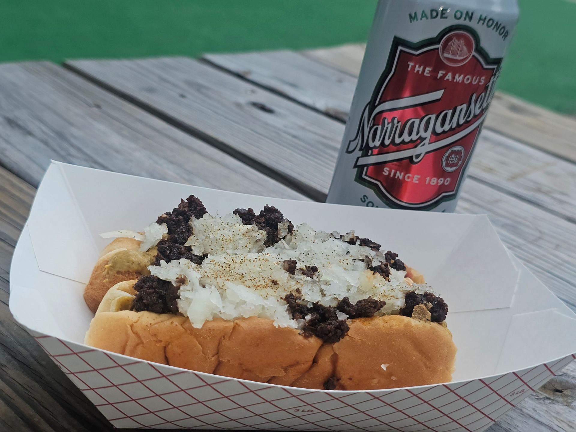 A can of lite beer next to a wiener.