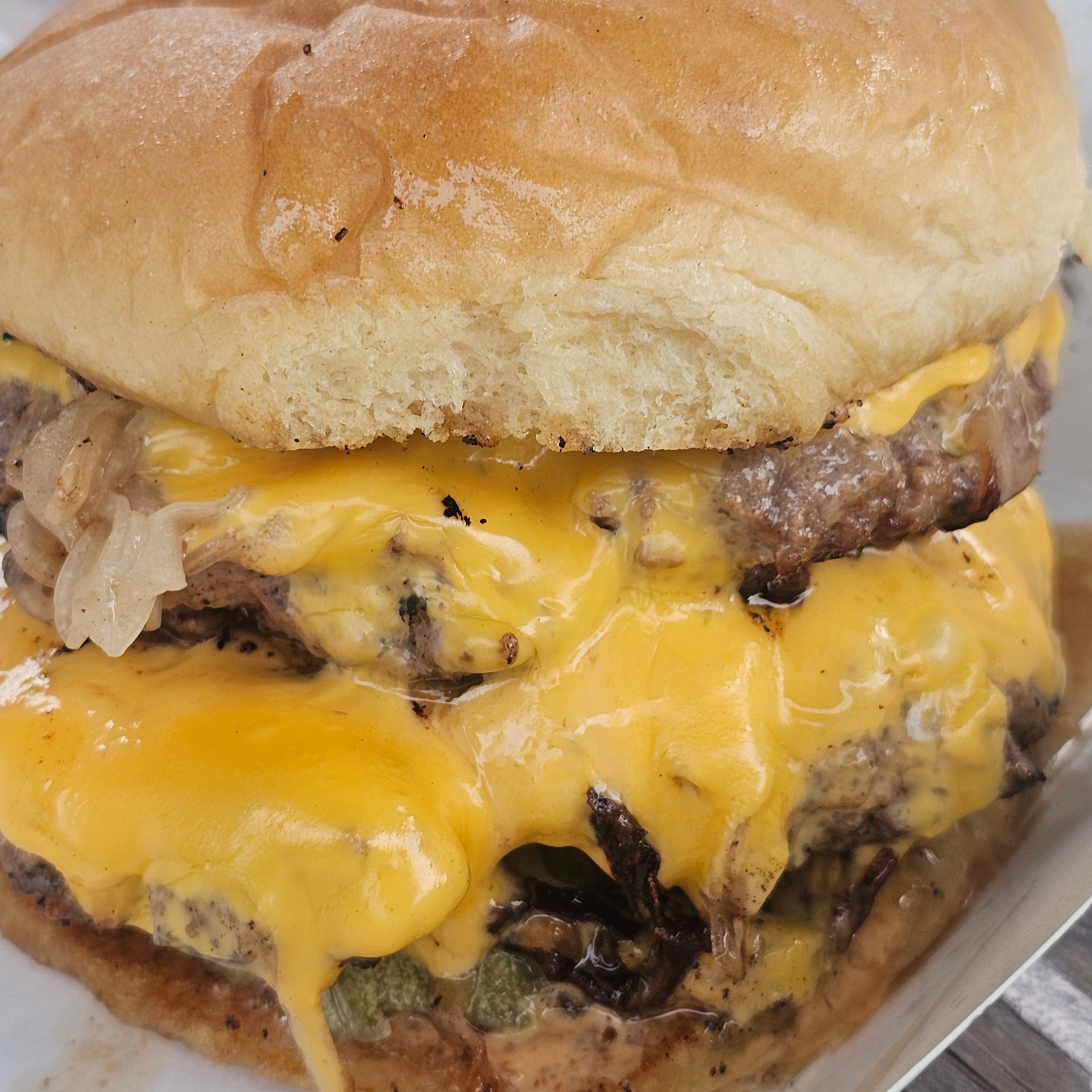 A close up of a cheeseburger on a bun.