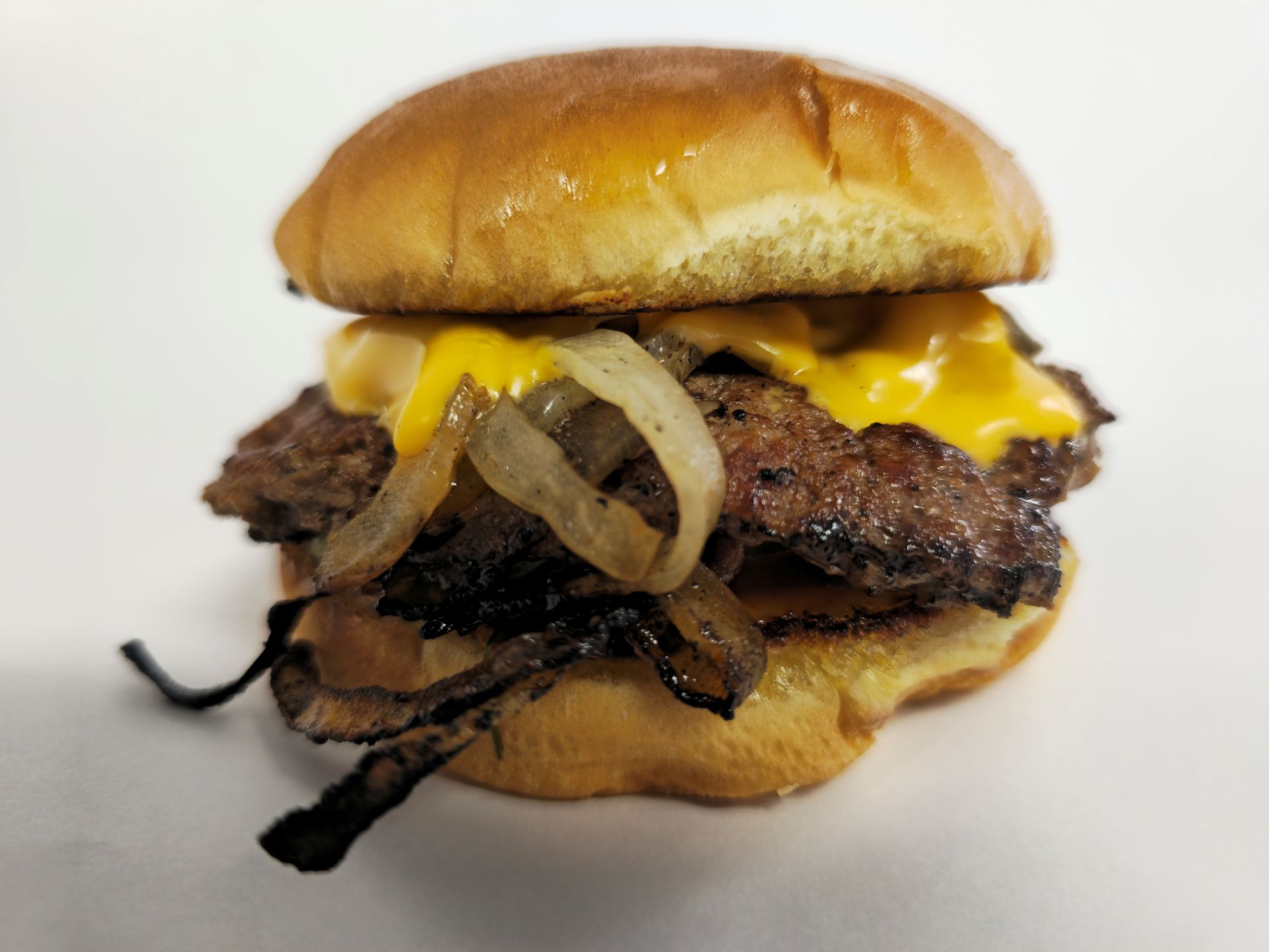 Double meat patty hamburger with onions and a bun.
