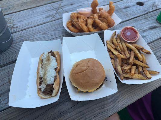A wiener, hamburger, fries, and onion rings.