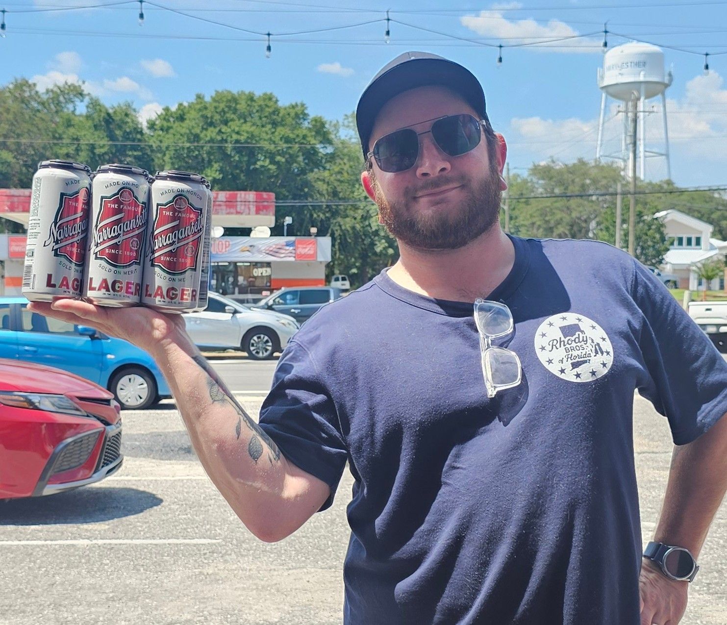 Owner holding a 6-pack of Narragansett beer.