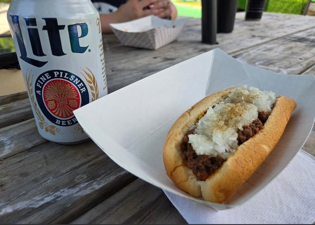 A can of lite beer next to a wiener.