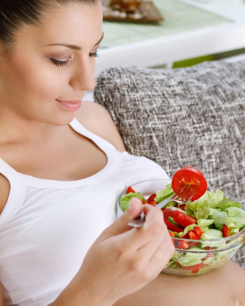 Pregnant woman eats salad