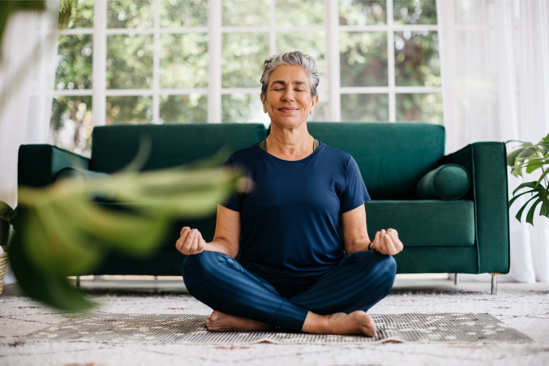 Senior woman meditating at home