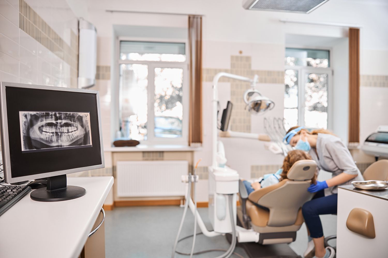 A woman in a dental chair reviewing her treatment on a computer at a local dentist.